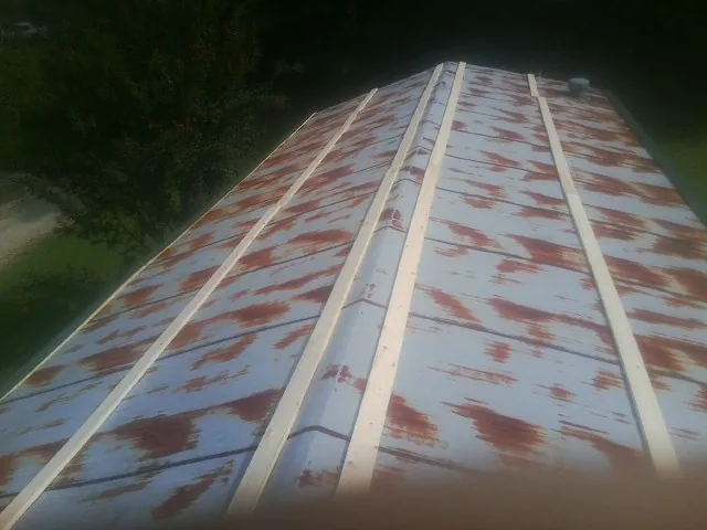 Rusted metal roof panels with new wood purlins before replacement — Storm Damage Roof Repair in Springdale by Roofing Brothers